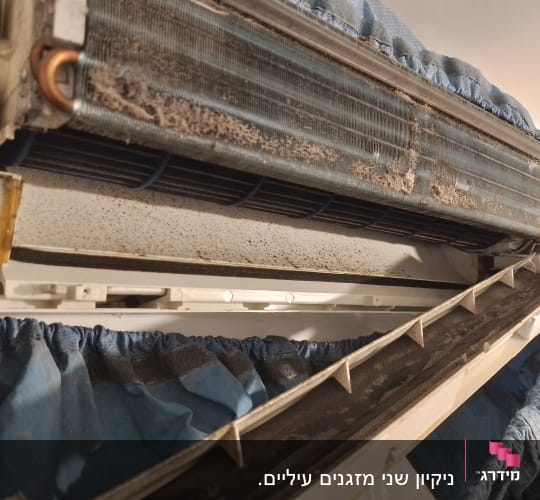 יחידת מזגן עם לכלוך ואבק על הסלילים והחלקים הפנימיים
